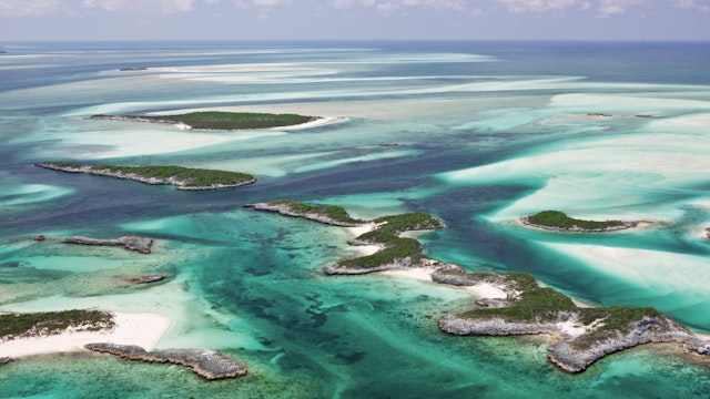 Aerial view of the islands, beautiful sandy bottom and green water contours of the Exumas in the Bahamas.